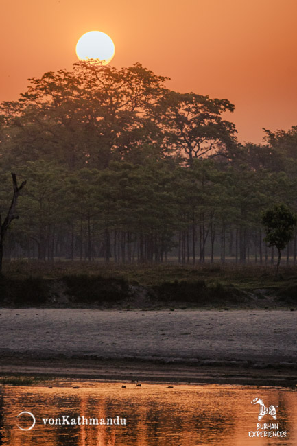 Golden sunrise over Khauraha river, a channel of Karnali seen during morning bush walk in the community forest