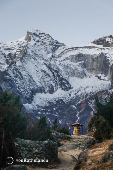 Buddhist prayer wheel in Namche outskirts beneath Kongde mountain