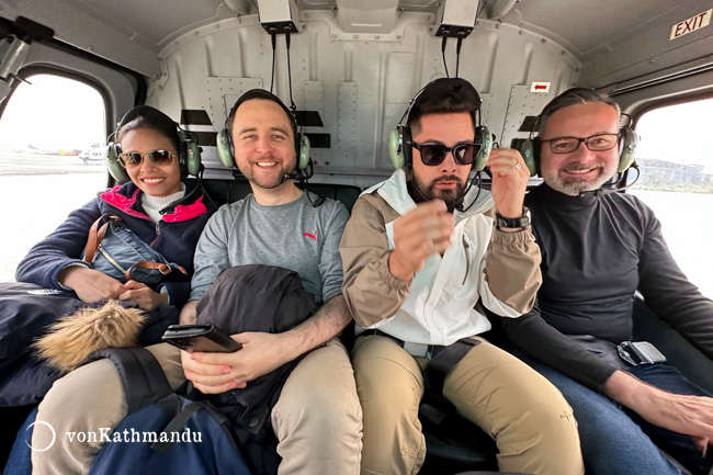 Passengers in the back seat of the helicopter ready with their headsets on.