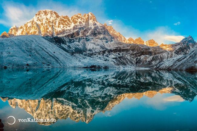 Still waters of Gokyo Lake catch reflection of its rocky surrounding