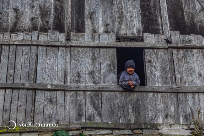 A little girl greeting trekkers passing by her house