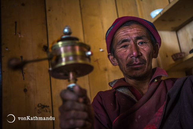 Buddhist monk spinning a mane, a mini prayer wheel