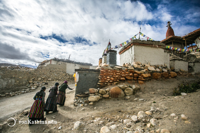 Women walking in clockwise direction around the walled fortress of Lo Manthan. This ritual is called Kora, and performed daily by many locals here.