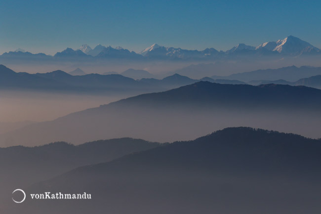 Layers of hills merge into snowcapped Himalayas