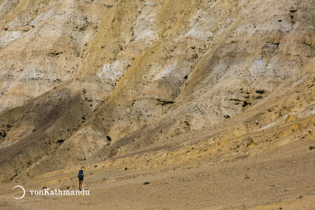 Trekker walks by erratic formations in Upper Mustang